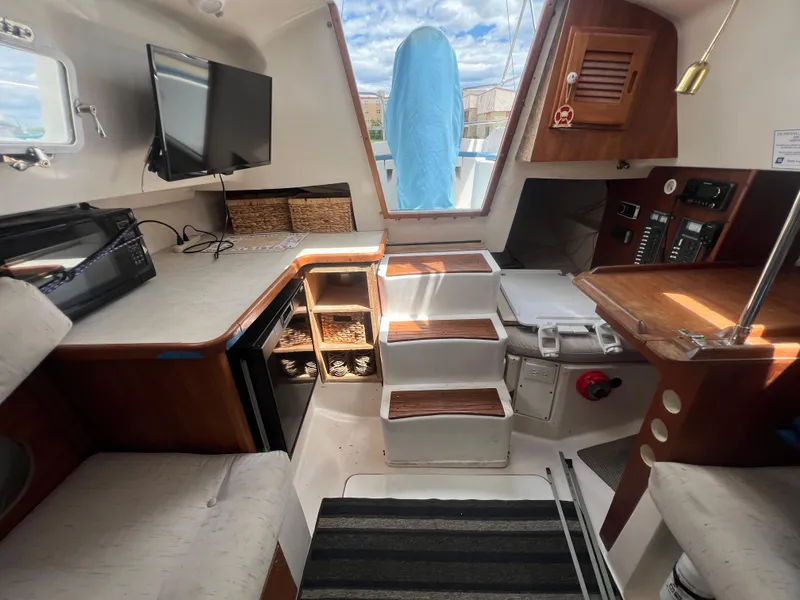 Slide: The Image of Interior of a 1983 Hunter 27 sailboat with modern amenities and cozy seating. - 23
