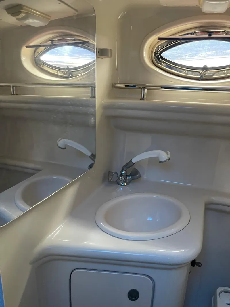 Slide: The Image of 2006 Sea Ray 270 Amberjack bathroom sink with mirror and porthole window. - 16