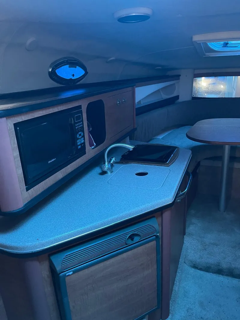 Slide: The Image of Interior cabin of a 2006 Sea Ray 270 Amberjack boat with kitchenette and seating area. - 17