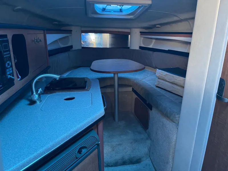 Slide: The Image of Interior cabin of a 2006 Sea Ray 270 Amberjack boat with kitchenette and seating area. - 18
