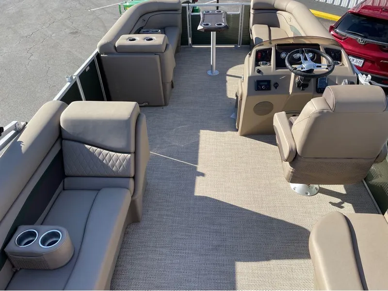 Slide: The Image of 2023 Bennington 20 SSRSP pontoon boat interior with beige seating and steering console. - 2