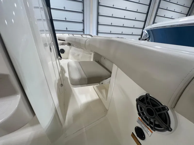 Slide: The Image of 2025 Boston Whaler 250 Outrage interior with cushioned seating and speaker. - 11