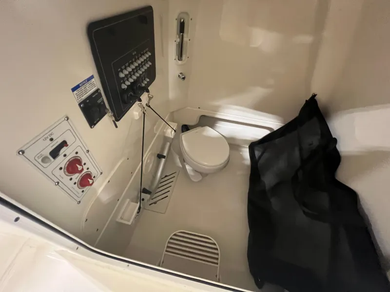 Slide: The Image of Interior of 2025 Boston Whaler 250 Outrage boat with toilet and control panel. - 13