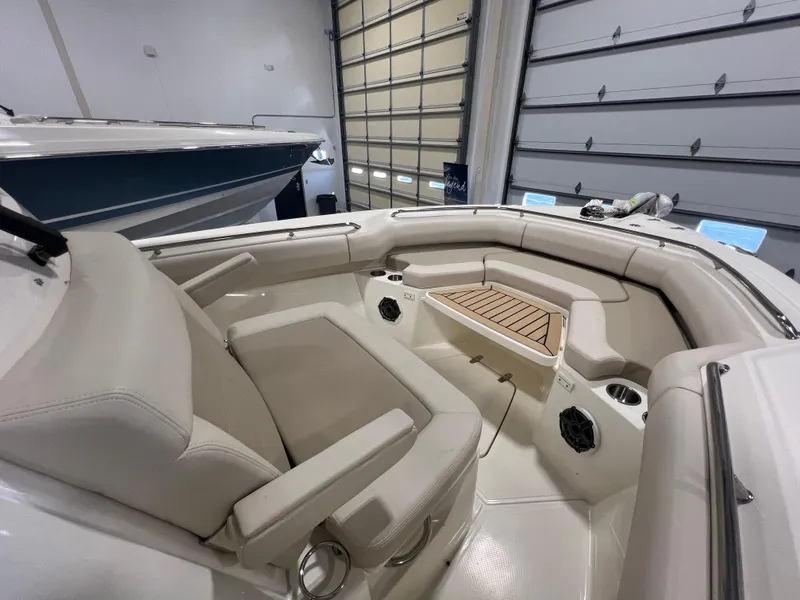 Slide: The Image of 2025 Boston Whaler 250 Outrage boat interior with beige seating and wood accents. - 14