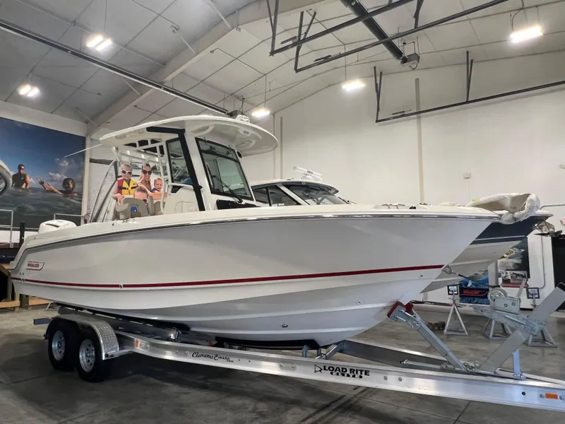 Slide: The Image of 2025 Boston Whaler 250 Outrage boat on trailer in showroom. - 2