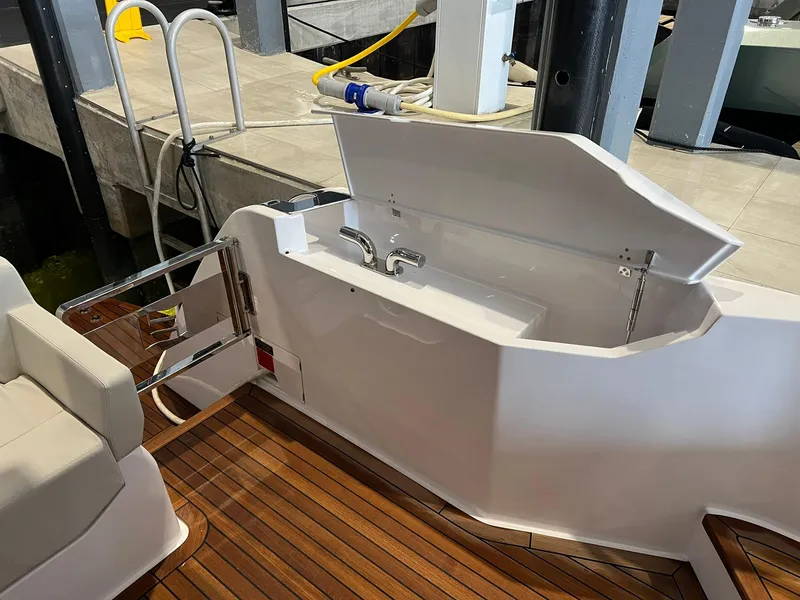 Slide: The Image of 2024 Ferretti Yachts 500 deck with open storage compartment and wooden flooring. - 6