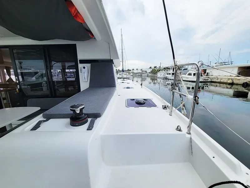 Slide: The Image of 2017 Lagoon 42 catamaran docked at a marina, featuring a spacious deck and modern design. - 10