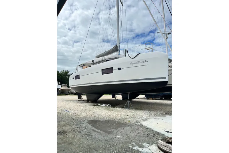 Slide: The Image of 2017 Lagoon 42 catamaran on land, white hull, overcast sky background. - 39