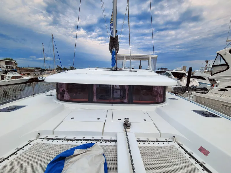 Slide: The Image of 2017 Lagoon 42 catamaran docked at marina under cloudy sky. - 8