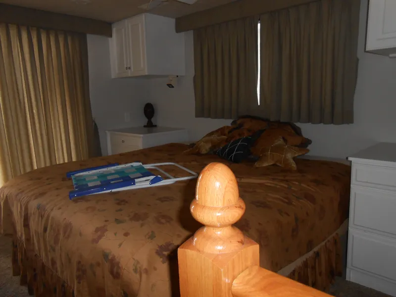 Slide: The Image of Bedroom interior of 2000 Skipperliner Custom Houseboat with bed, curtains, and cabinets. - 10