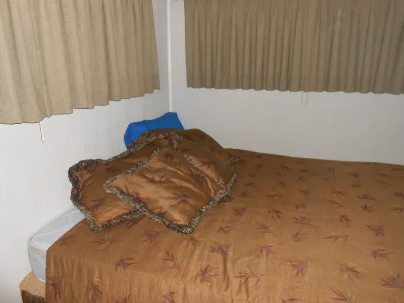 Slide: The Image of Bedroom interior of 2000 Skipperliner Custom Houseboat with brown bedding and curtains. - 13