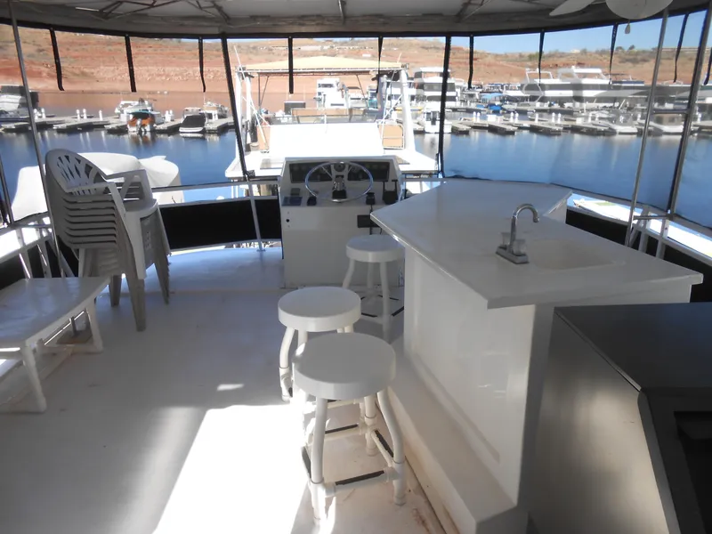 Slide: The Image of 2000 Skipperliner Custom Houseboat interior with bar stools and marina view. - 17