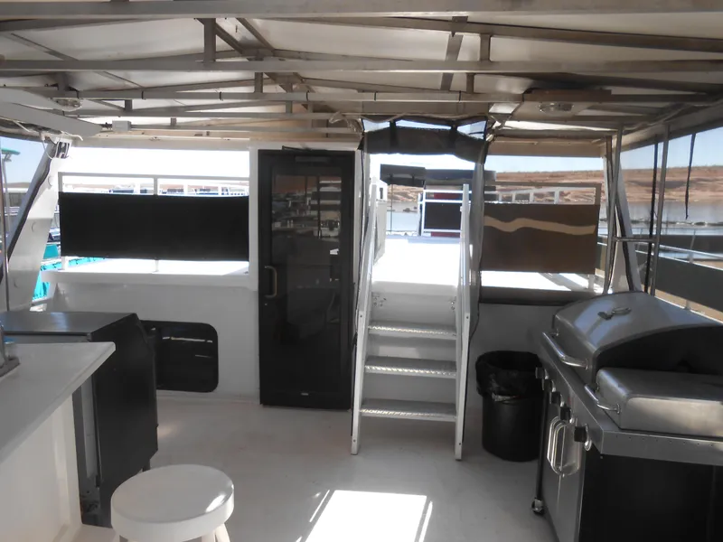 Slide: The Image of Interior of a 2000 Skipperliner Custom Houseboat with stairs, grill, and seating area. - 18