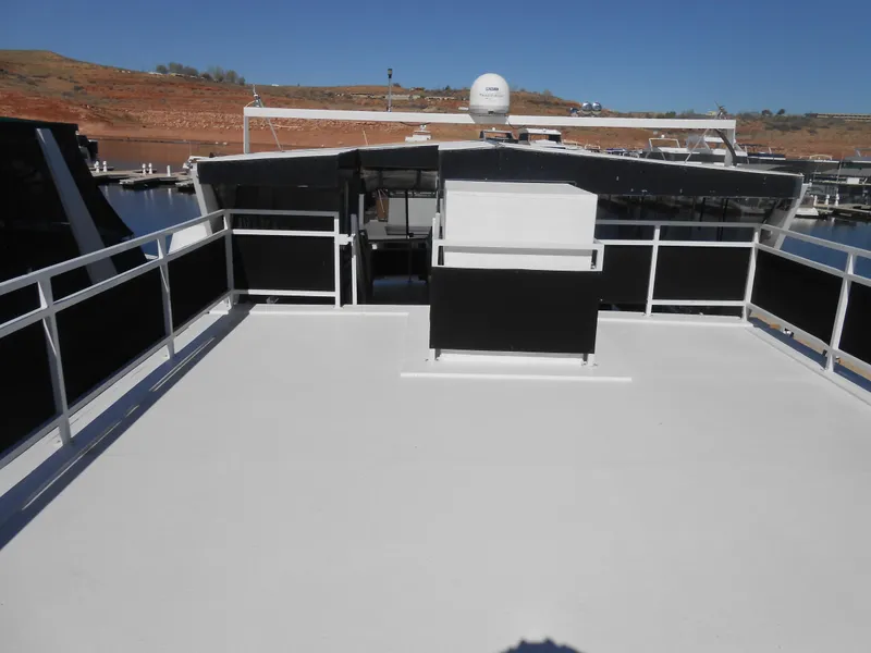 Slide: The Image of Upper deck of a 2000 Skipperliner Custom Houseboat docked at a marina. - 21