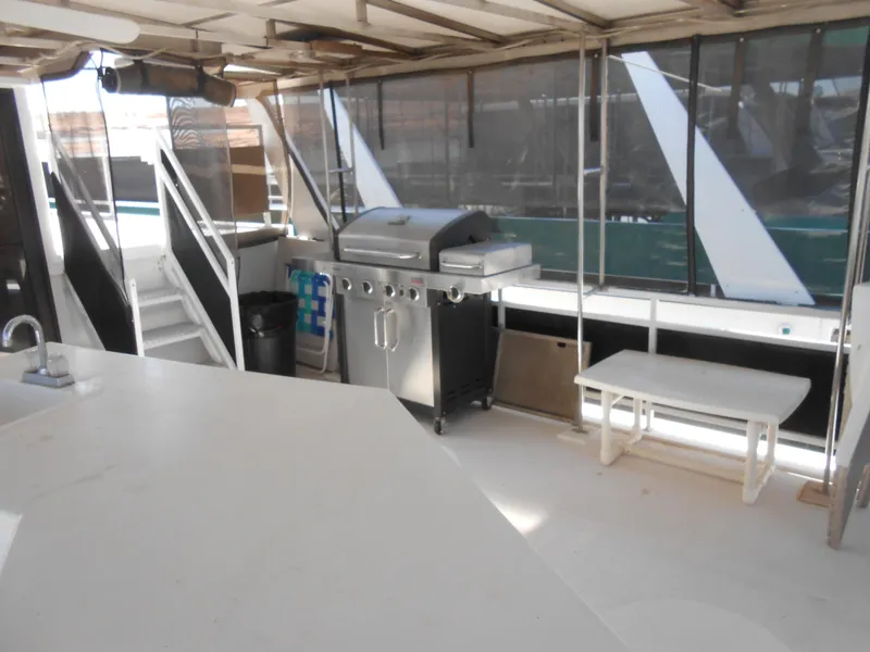 Slide: The Image of Outdoor deck of 2000 Skipperliner Custom Houseboat with grill, table, and sink. - 23