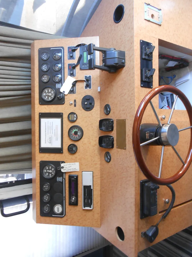 Slide: The Image of Control panel of a 2000 Skipperliner Custom Houseboat with steering wheel and gauges. - 26