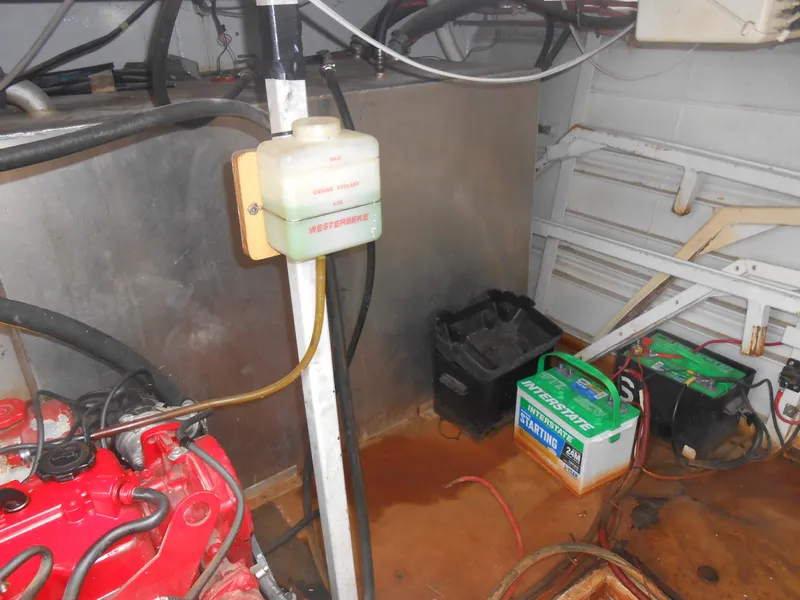 Slide: The Image of Engine room of a 2000 Skipperliner Custom Houseboat with batteries and engine components. - 32