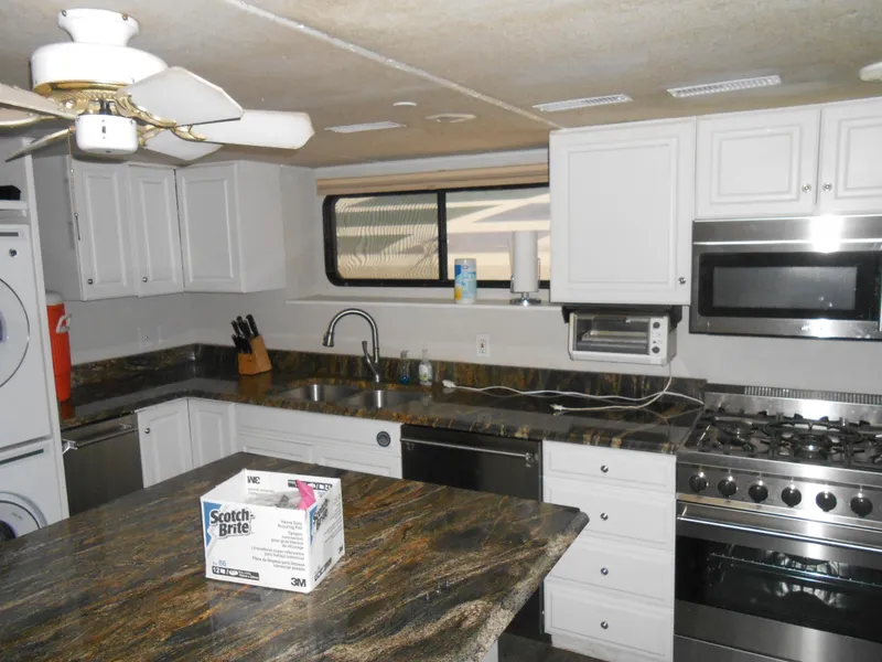 Slide: The Image of 2000 Skipperliner Custom Houseboat kitchen with modern appliances and granite countertops. - 5