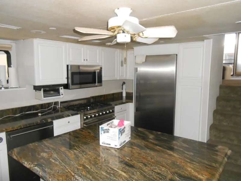 Slide: The Image of Modern kitchen in a 2000 Skipperliner Custom Houseboat with granite countertops and stainless steel appliances. - 7
