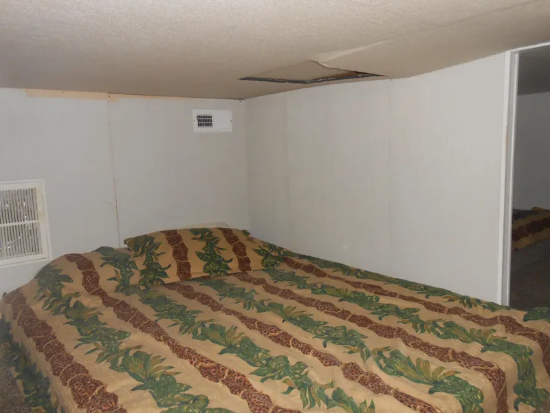 Slide: The Image of Small bedroom in 2000 Skipperliner Custom Houseboat with tropical-themed bedding. - 9