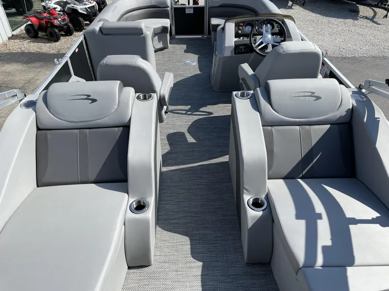 Slide: The Image of 2023 Bennington 22 SXCWSP pontoon boat interior with gray seating and steering console. - 2