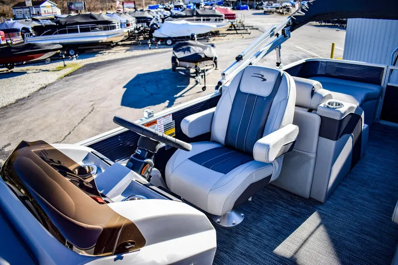 Slide: The Image of 2023 Bennington 22 SXCWSP pontoon boat interior with captain's chair and helm. - 17