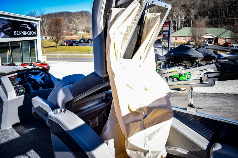 Slide: The Image of 2023 Bennington 22 SXCWSP boat interior with protective cover, displayed at dealership. - 30