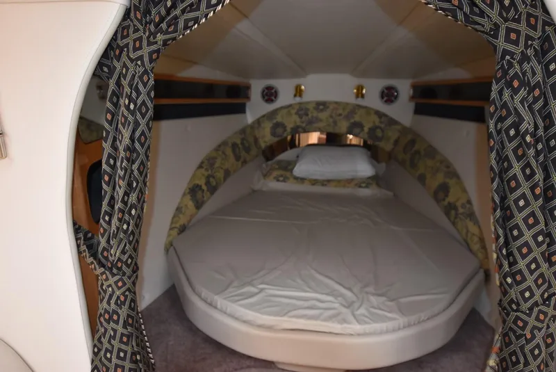 Slide: The Image of 2002 Black Thunder 460 EC cabin with cozy bed and patterned curtains. - 17