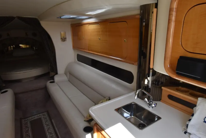 Slide: The Image of Interior of a 2002 Black Thunder 460 EC boat with white leather seating and kitchenette. - 19