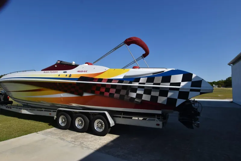 Slide: The Image of 2002 Black Thunder 460 EC powerboat with vibrant racing graphics on a trailer. - 2