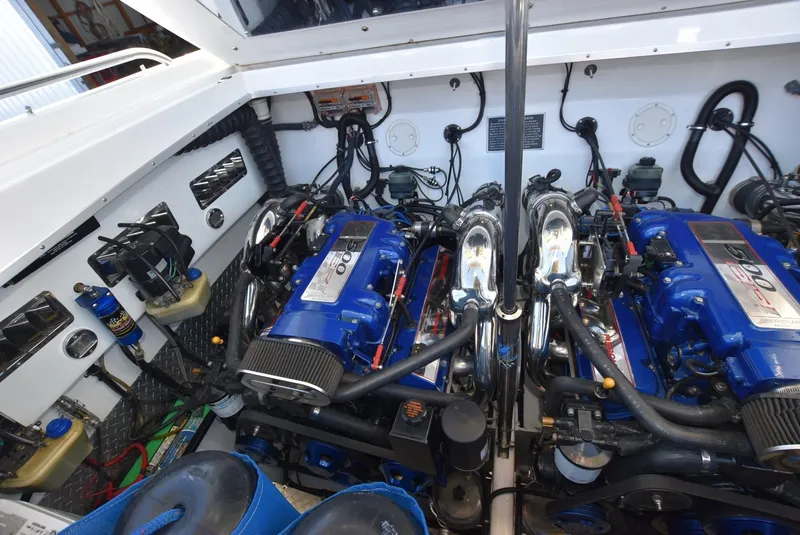 Slide: The Image of Engine compartment of a 2002 Black Thunder 460 EC boat with dual blue engines. - 37
