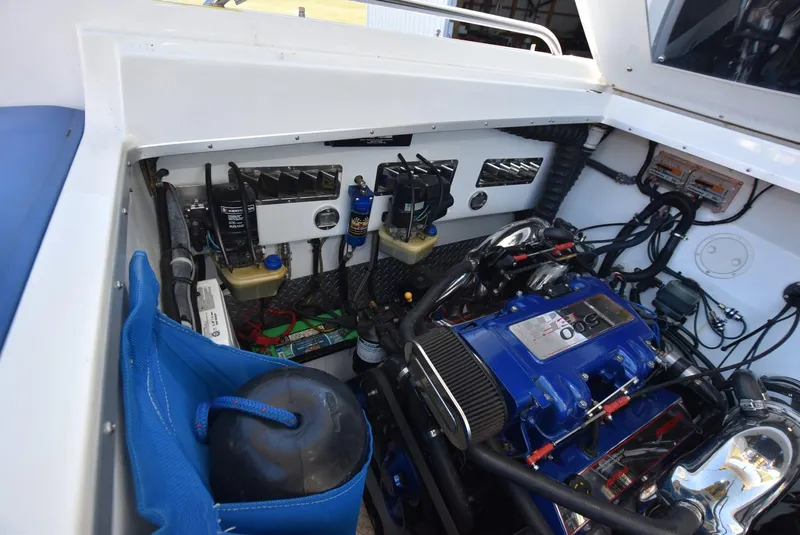Slide: The Image of Engine compartment of a 2002 Black Thunder 460 EC boat with blue engine components. - 38