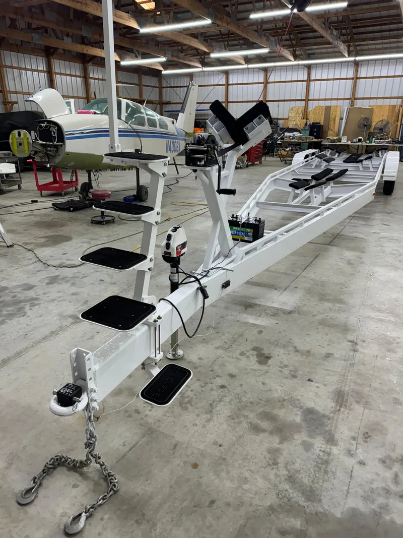 Slide: The Image of White 2002 Black Thunder 460 EC boat trailer in a spacious garage with aircraft. - 46