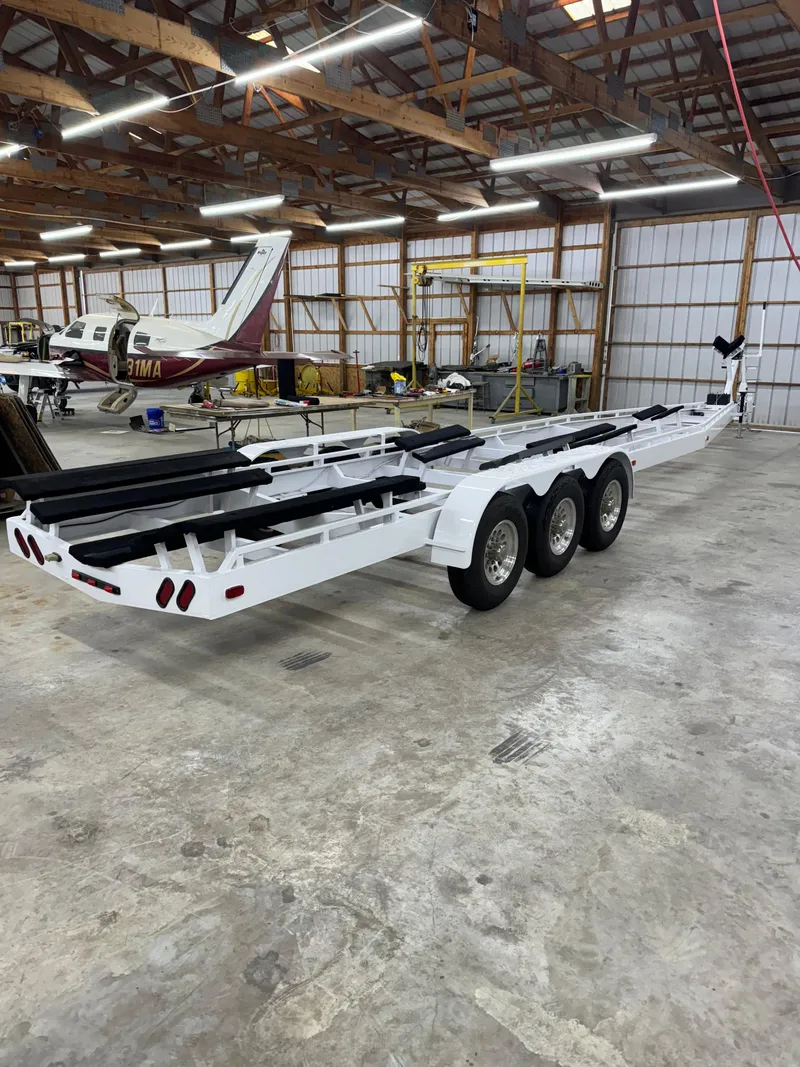 Slide: The Image of 2002 Black Thunder 460 EC boat trailer in a spacious hangar. - 47