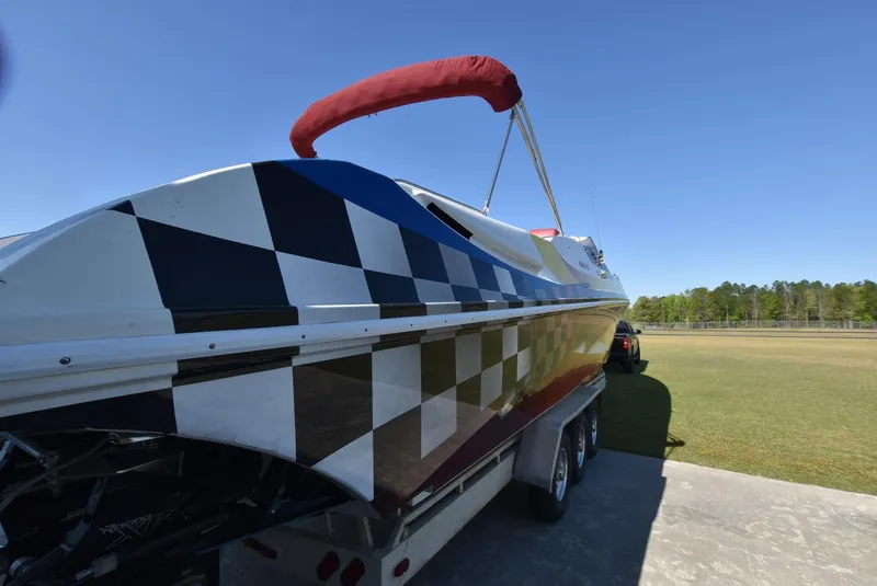 Slide: The Image of 2002 Black Thunder 460 EC boat with checkered pattern on trailer. - 6