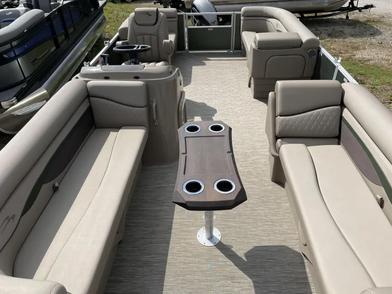 Slide: The Image of 2024 Bennington 20 SSRSP pontoon boat interior with beige seating and a central table. - 2