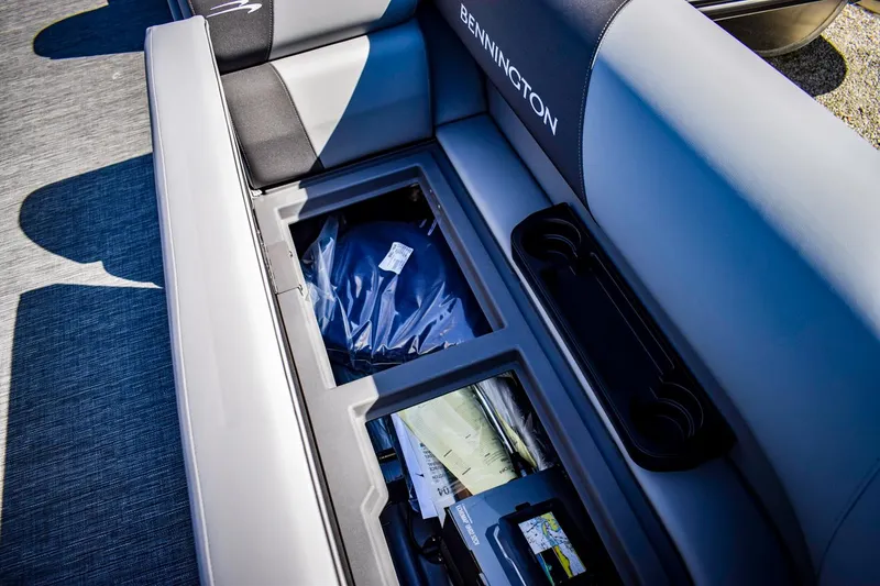 Slide: The Image of 2024 Bennington 20 SVLSR boat storage compartment with open seat and visible storage items. - 8