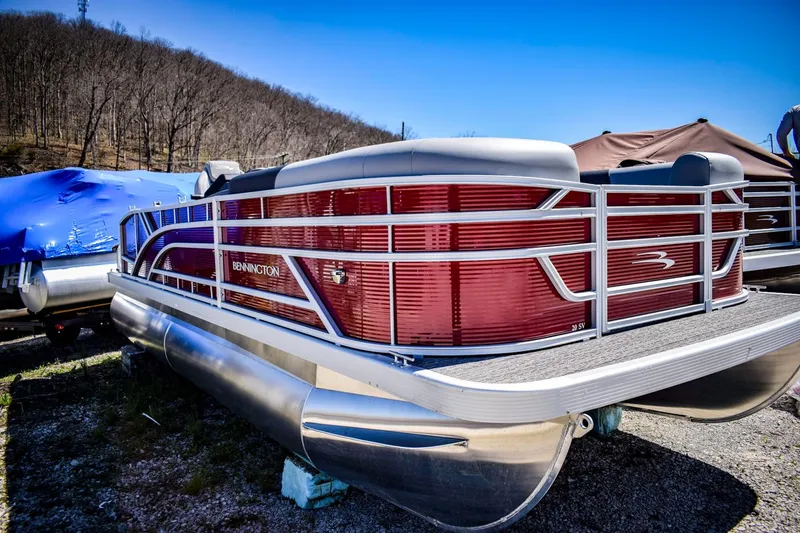Slide: The Image of 2024 Bennington 20 SVSBSR pontoon boat in a storage yard. - 2