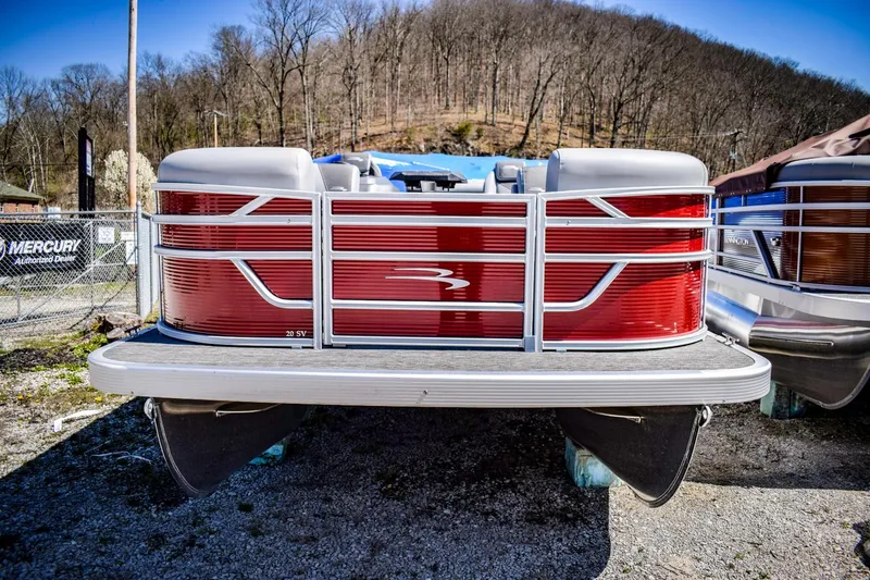 Slide: The Image of 2024 Bennington 20 SVSBSR pontoon boat, front view, red and silver, parked on gravel. - 3
