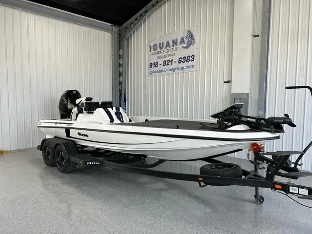 Slide: The Image of 2024 iKon LX20 boat on trailer in showroom, Iguana Marine Group sign in background. - 3