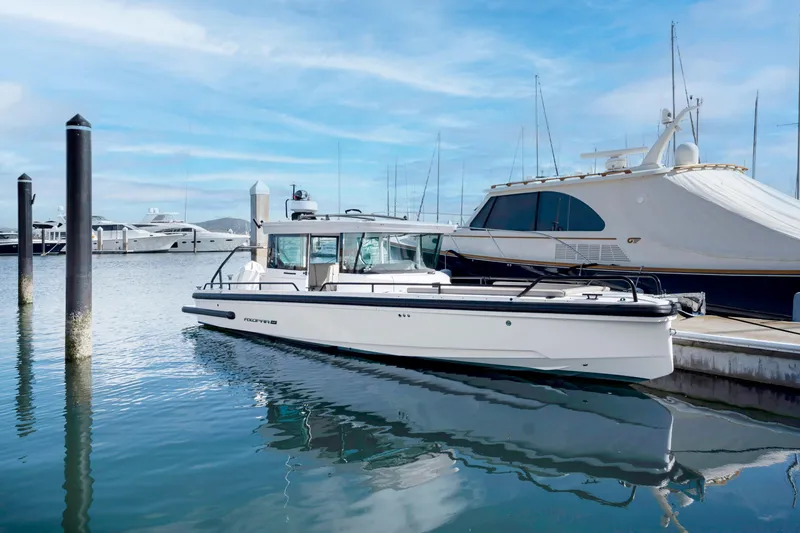 Slide: The Image of 2022 Axopar 28 CABIN boat docked at a marina. - 1