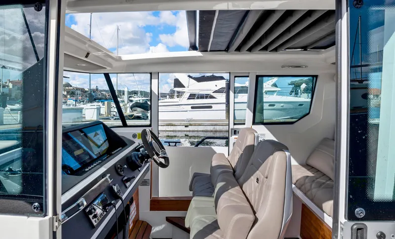 Slide: The Image of Interior of 2022 Axopar 28 CABIN boat with modern dashboard and seating. - 10