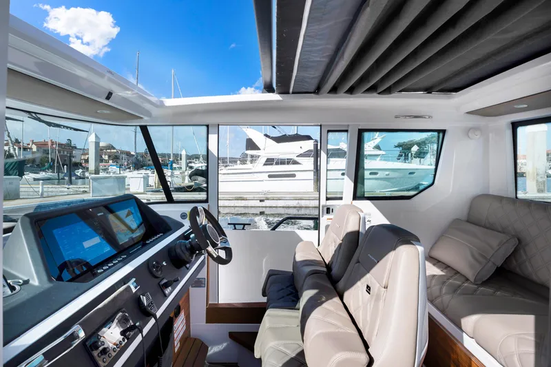 Slide: The Image of Interior of 2022 Axopar 28 CABIN boat with modern dashboard and comfortable seating. - 11