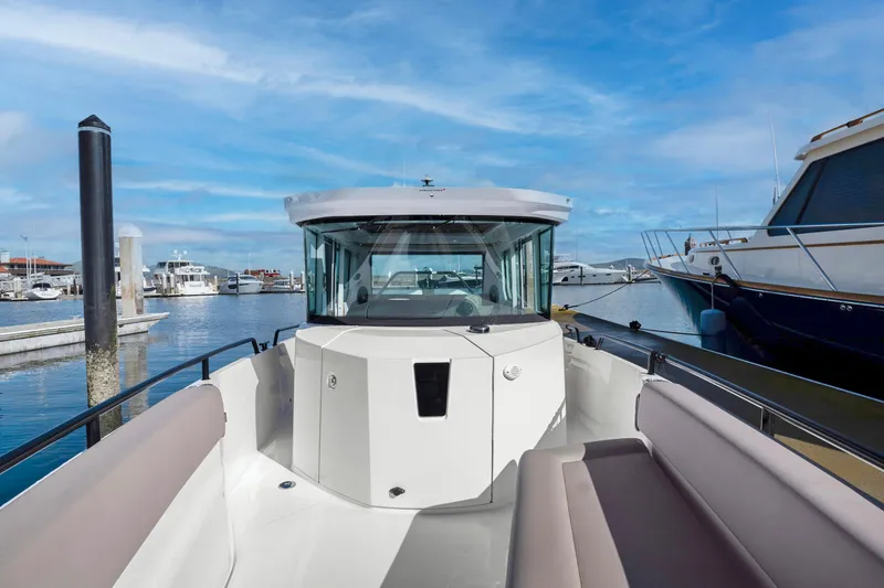 Slide: The Image of 2022 Axopar 28 CABIN boat docked at a marina with blue skies. - 12