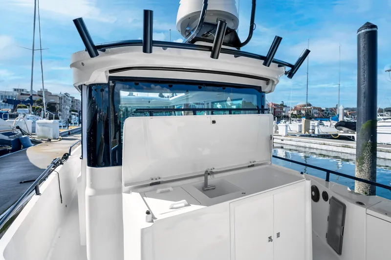 Slide: The Image of 2022 Axopar 28 CABIN boat with open deck and marina background. - 14