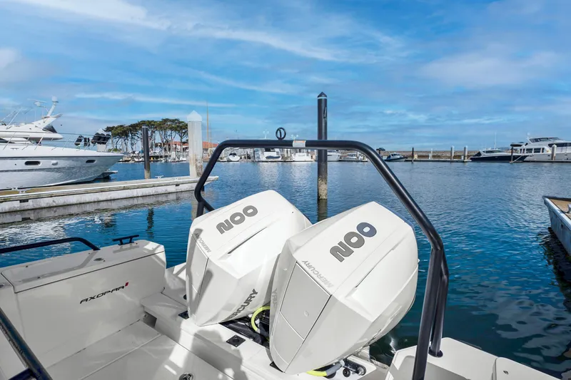 Slide: The Image of Axopar 28 CABIN 2022 model with twin engines docked at a marina. - 15