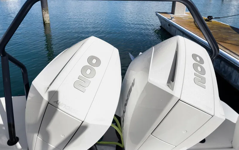 Slide: The Image of Twin outboard engines on a 2022 Axopar 28 CABIN boat docked by the water. - 18