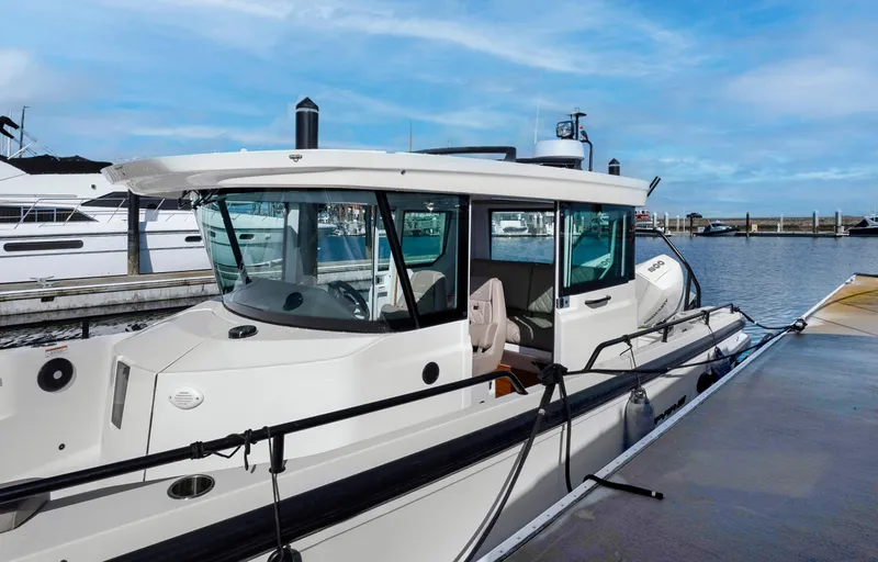 Slide: The Image of 2022 Axopar 28 CABIN boat docked at a marina on a sunny day. - 20