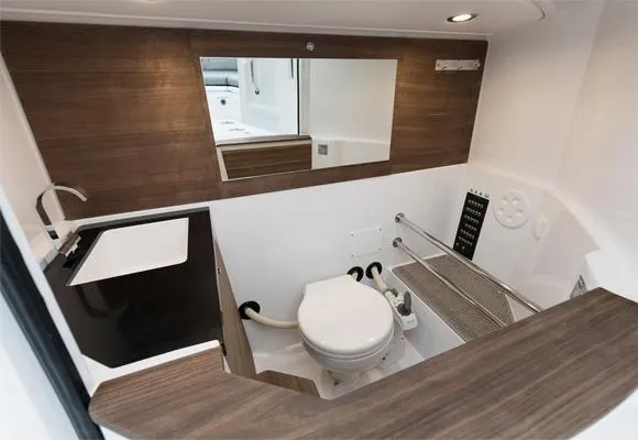 Slide: The Image of Modern bathroom in 2022 Axopar 28 CABIN boat with wood accents and sleek fixtures. - 26