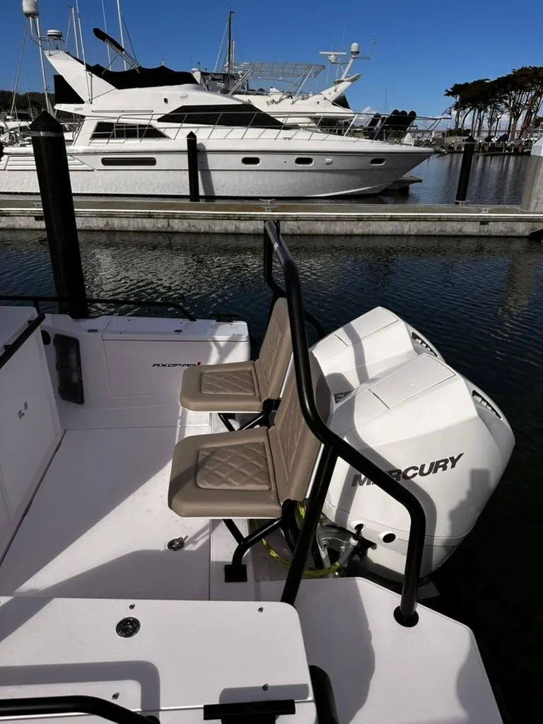 Slide: The Image of 2022 Axopar 28 CABIN boat with Mercury engines docked in a marina. - 27